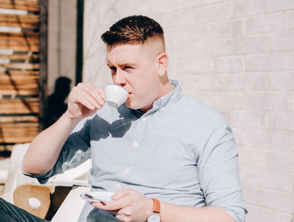 man sipping an espresso