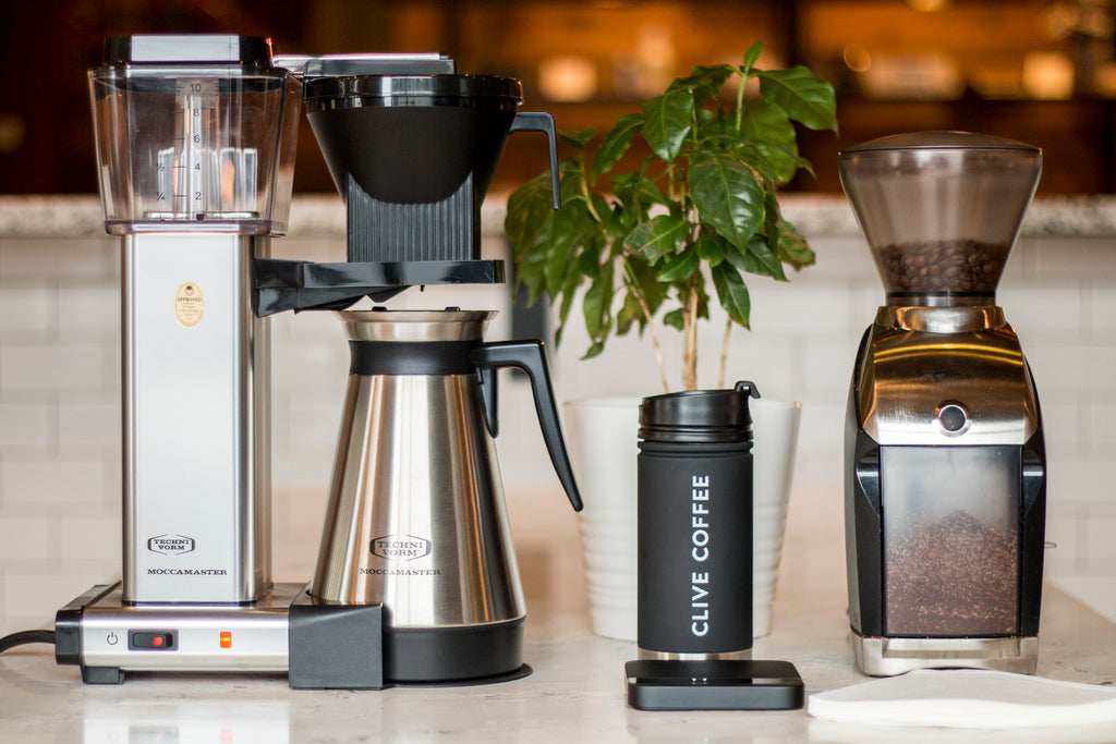 Technivorm Moccamaster coffee maker with thermal carafe in stainless steel on a counter alongside a Baratza Virtuoso coffee grinder, Clive Coffee - Lifestyle